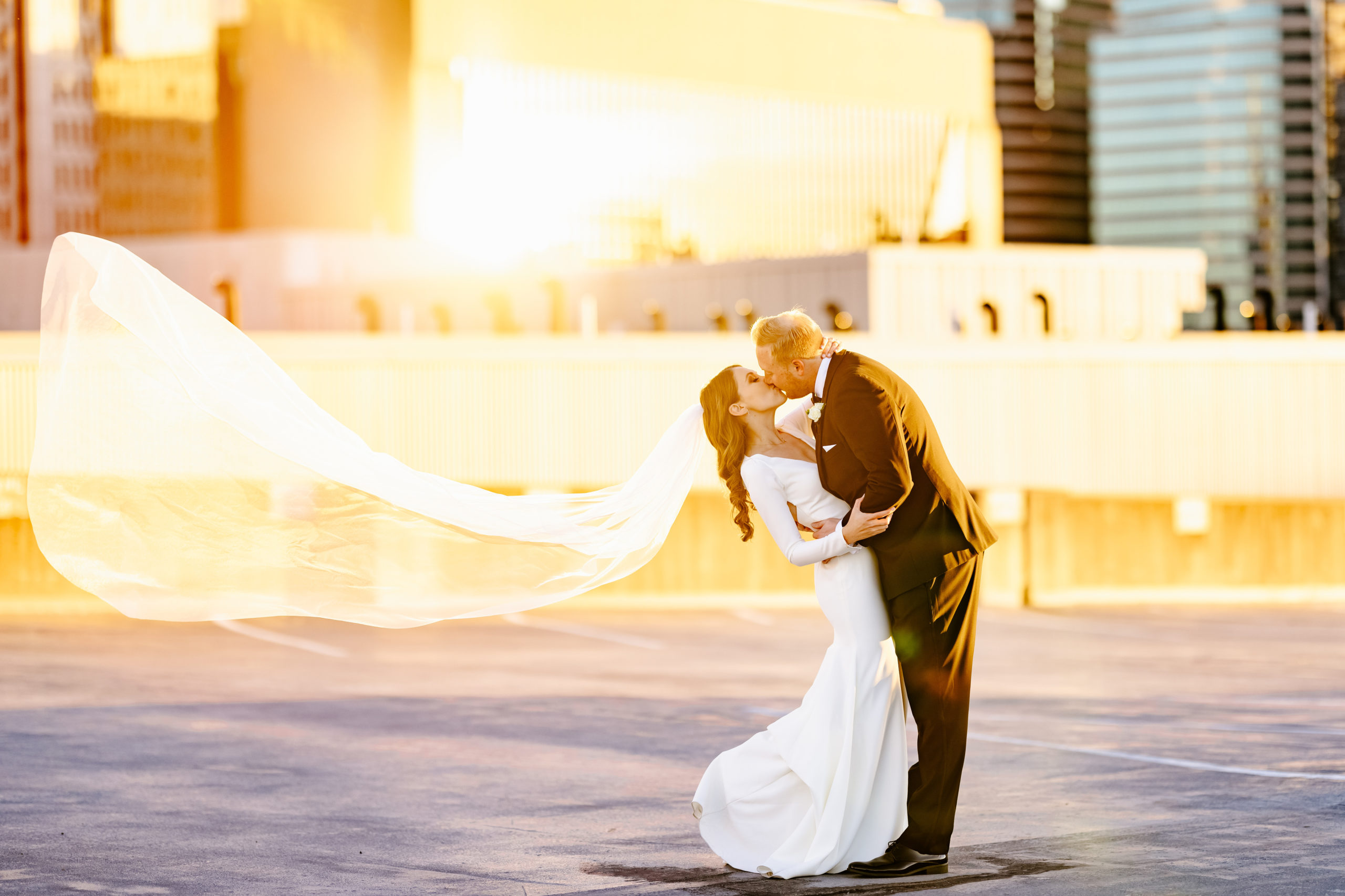 bride and groom kissing during sunset portraits