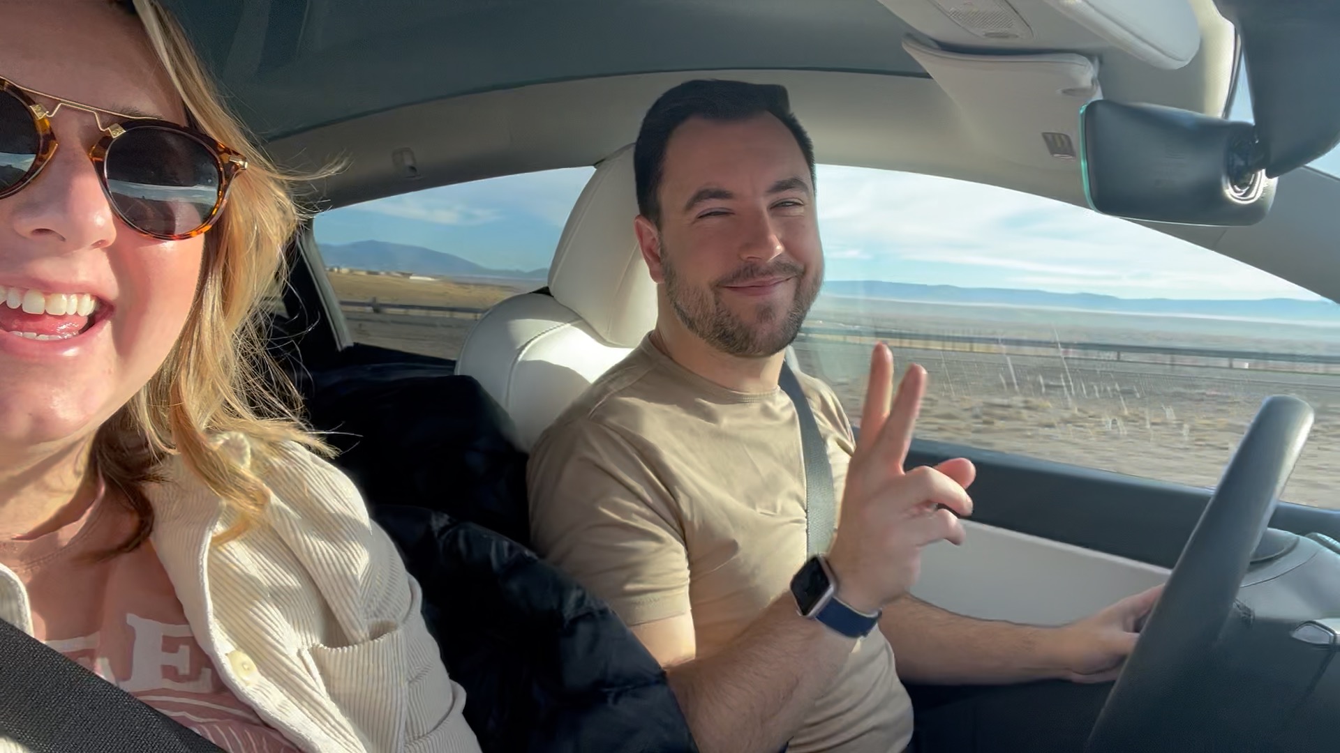 couple driving together in tesla on a road trip