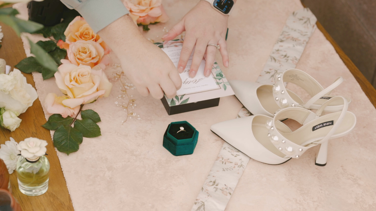 photographer styling wedding flatlay details in behind the scenes video
